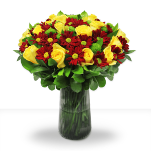 A flower arrangement of red and yellow flowers with green leaves in a glass vase