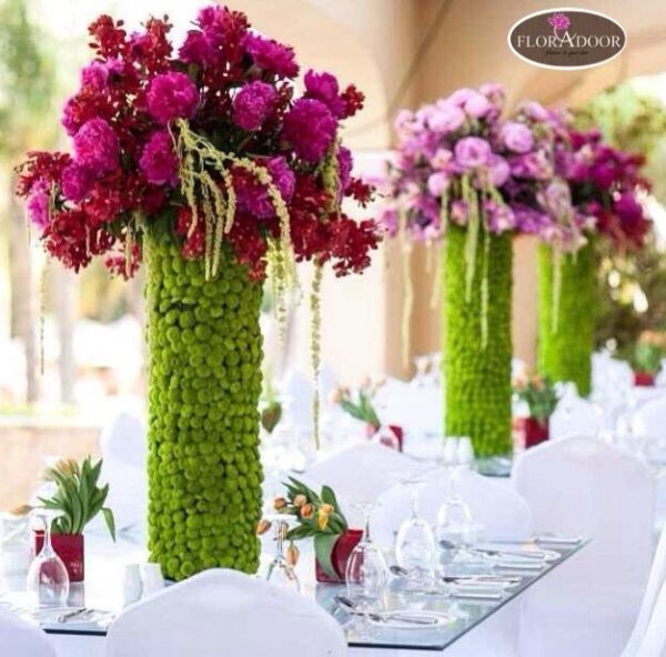 vase of pink flowers with greeny on table