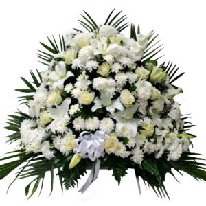 A flower vase with white roses and ruscus greenery and white lily and white chrysanthemum with a big ribbon